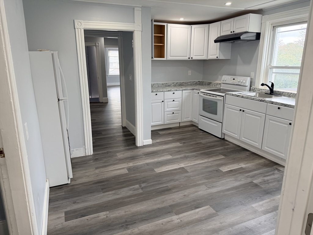 a kitchen with a sink cabinets stainless steel appliances and a window