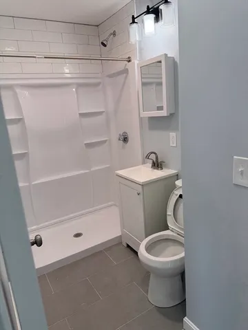 a bathroom with a sink a toilet and shower