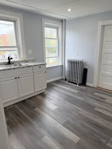 a view of a kitchen with wooden floor and a window