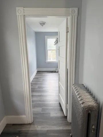 a view of empty room with wooden floor
