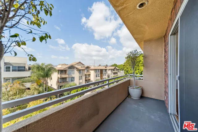 a view of a balcony with chairs and a potted plant