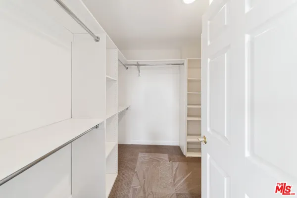 a view of walk in closet with empty racks
