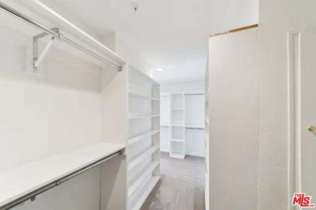 a view of walk in closet with empty racks