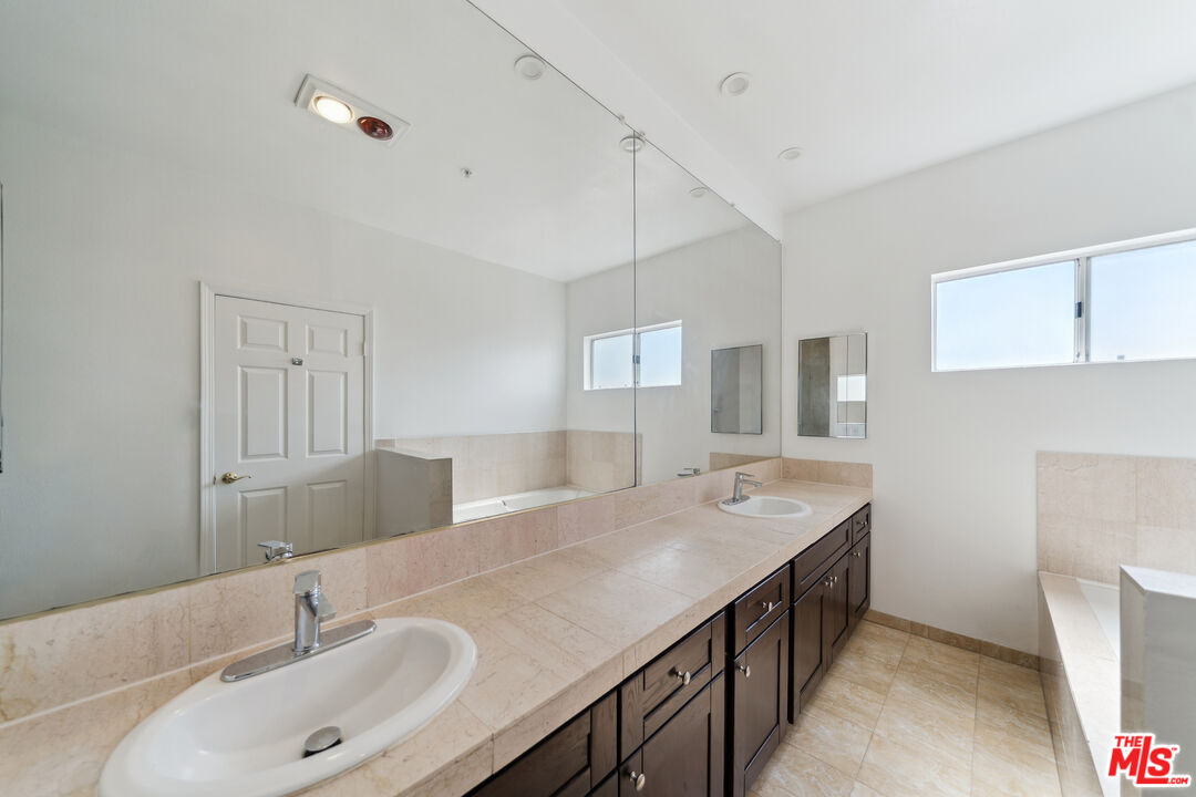 1508 Greenfield Avenue, Unit 307 Los Angeles, CA 90025 - Photo 20 of 27 a bathroom with a double vanity sink and mirror