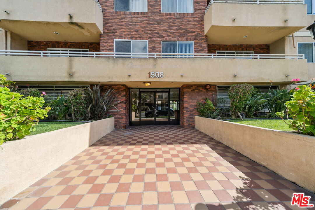 1508 Greenfield Avenue, Unit 307 Los Angeles, CA 90025 - Photo 25 of 27 a front view of a house with a garden