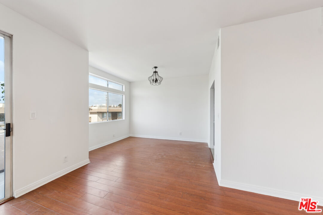 1508 Greenfield Avenue, Unit 307 Los Angeles, CA 90025 - Photo 3 of 27 an empty room with wooden floor cabinet and windows