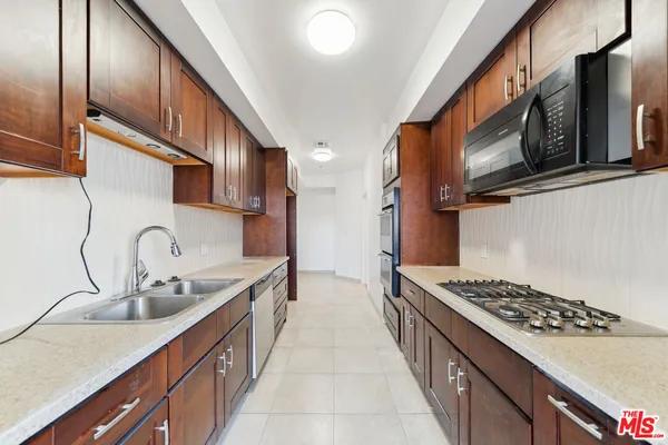 a kitchen with stainless steel appliances a sink stove and cabinets