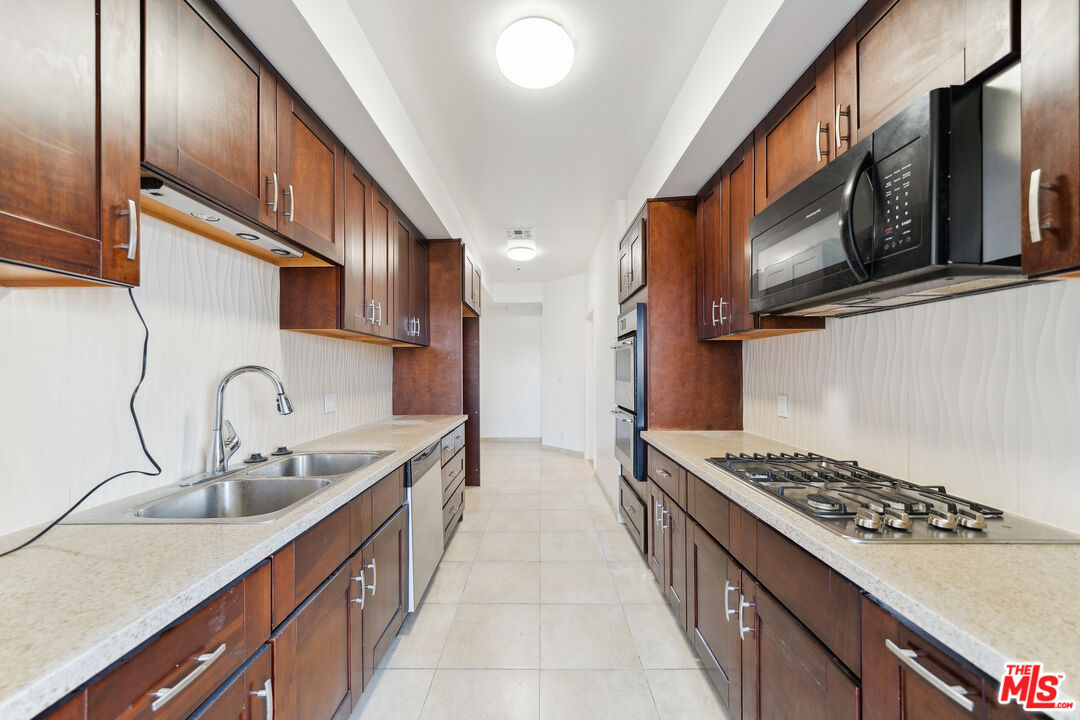 1508 Greenfield Avenue, Unit 307 Los Angeles, CA 90025 - Photo 5 of 27 a kitchen with stainless steel appliances a sink stove and cabinets