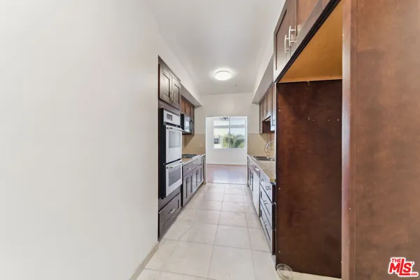 a hallway with a sink and a large mirror