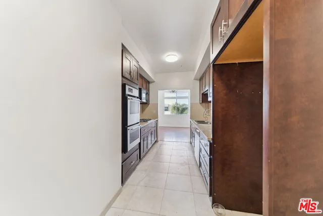 a hallway with a sink and a large mirror