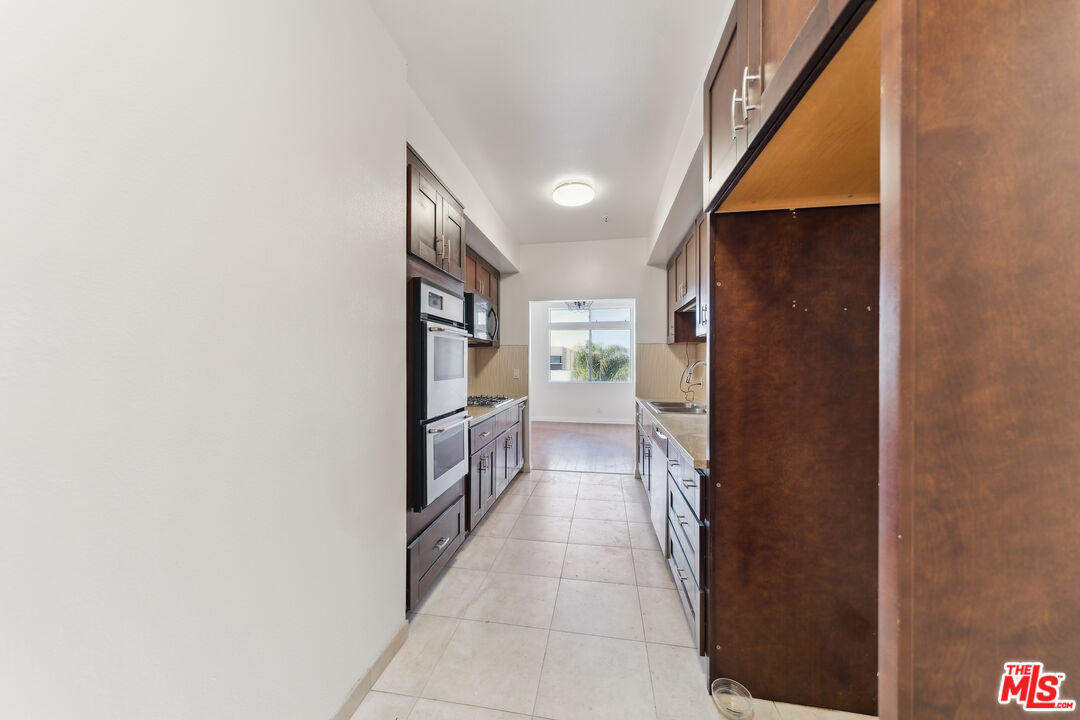 1508 Greenfield Avenue, Unit 307 Los Angeles, CA 90025 - Photo 7 of 27 a hallway with a sink and a large mirror