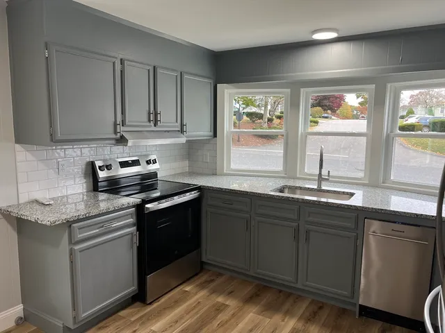 a kitchen with stainless steel appliances granite countertop a sink stove and cabinets