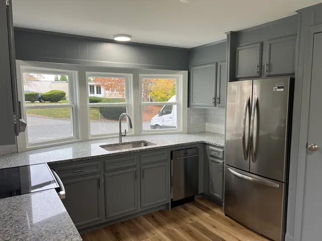 a kitchen with stainless steel appliances granite countertop a refrigerator and a sink