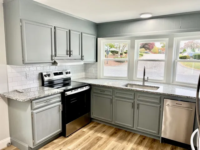 a kitchen with stainless steel appliances granite countertop a sink stove and cabinets