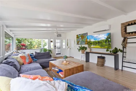 a living room with furniture a flat screen tv and a floor to ceiling window