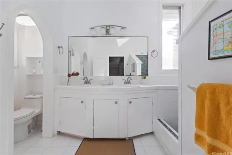 a bathroom with a double vanity sink toilet and a mirror