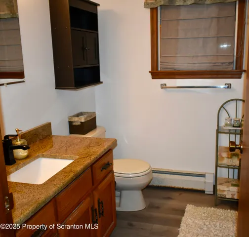 a bathroom with a granite countertop toilet sink and mirror