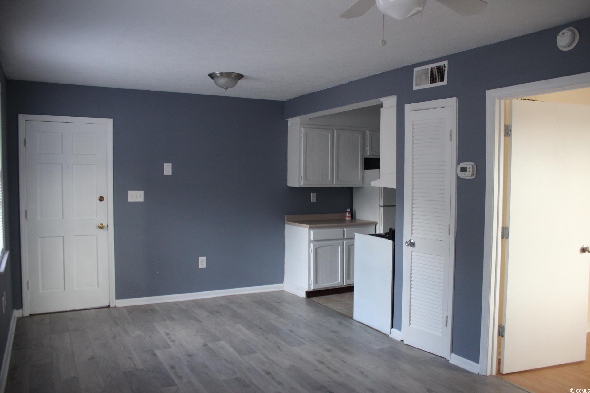 1500 Chester Street, Unit 2 Myrtle Beach, SC 29577 - Photo 6 of 9 Kitchen with white cabinetry, light wood-style floors, light countertops, and freestanding refrigerator