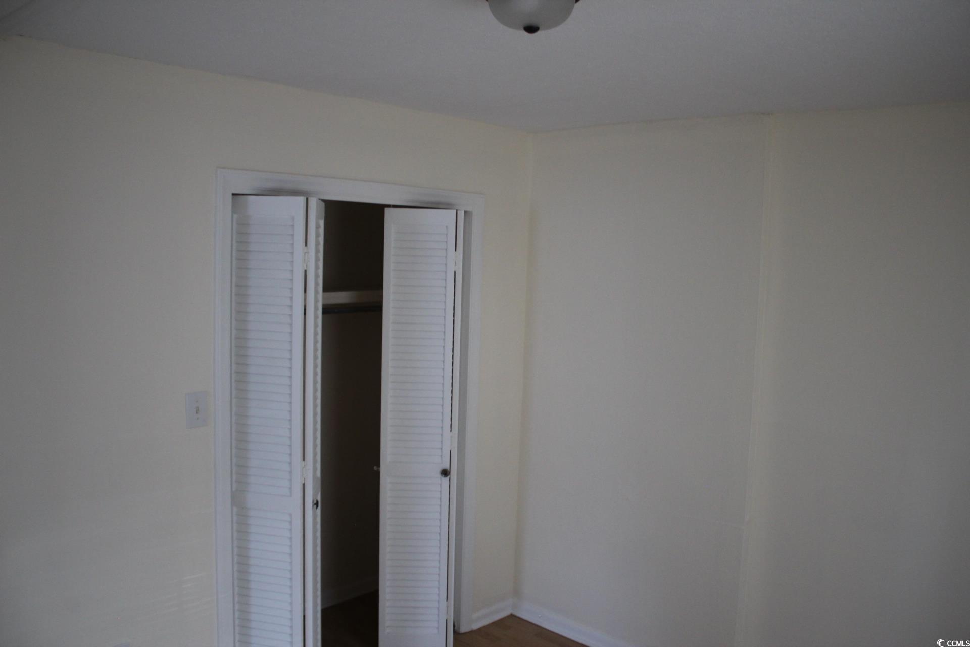 1500 Chester Street, Unit 2 Myrtle Beach, SC 29577 - Photo 8 of 9 Unfurnished bedroom with a closet and dark wood-style flooring