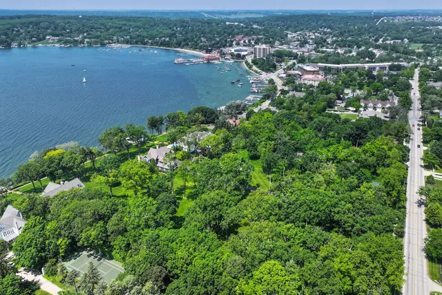 an aerial view of a houses with a yard and lake view