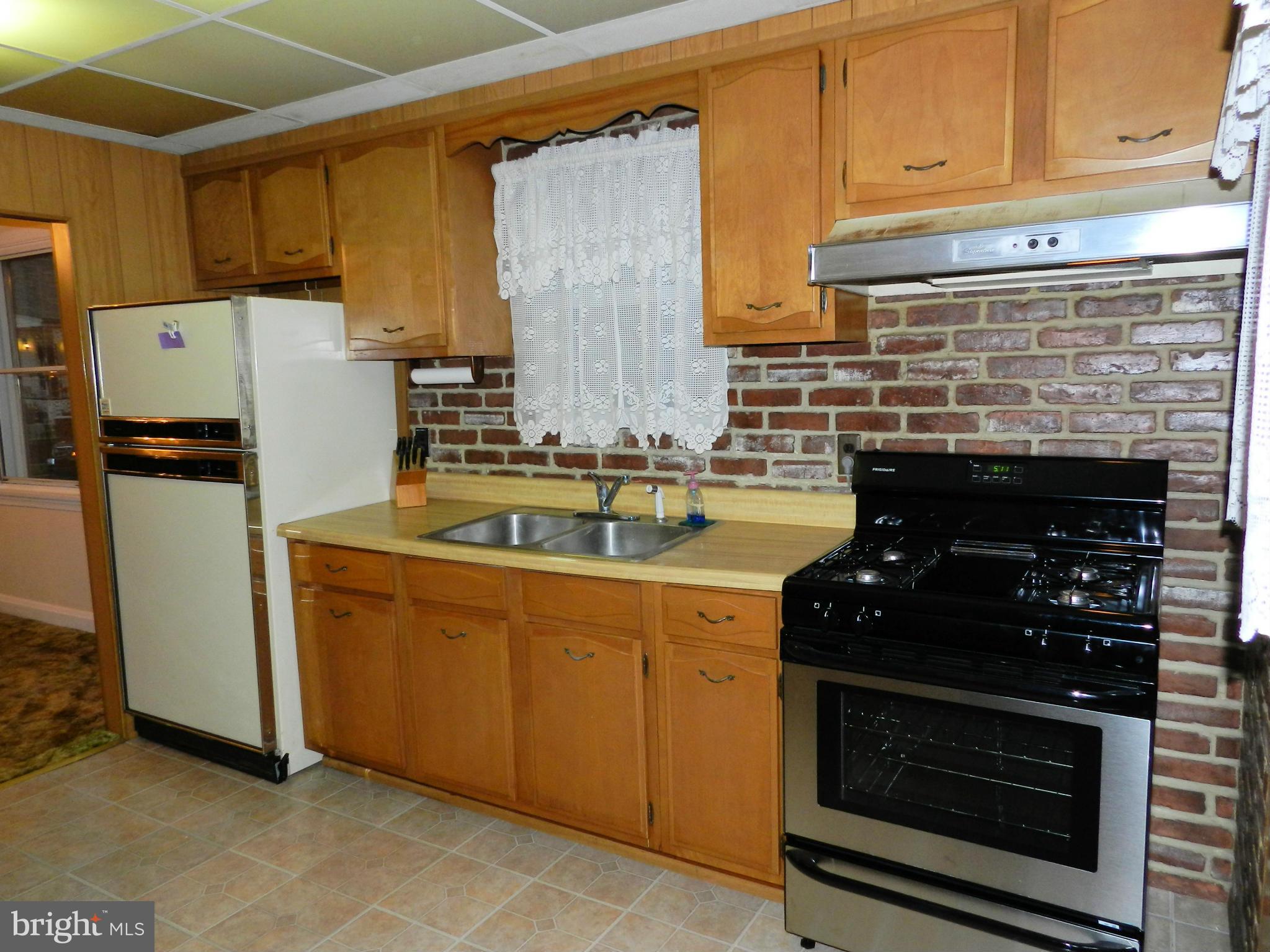 1502 Rita Road Dundalk, MD 21222 - Photo 5 of 21 a kitchen with stainless steel appliances granite countertop a stove a refrigerator and a sink