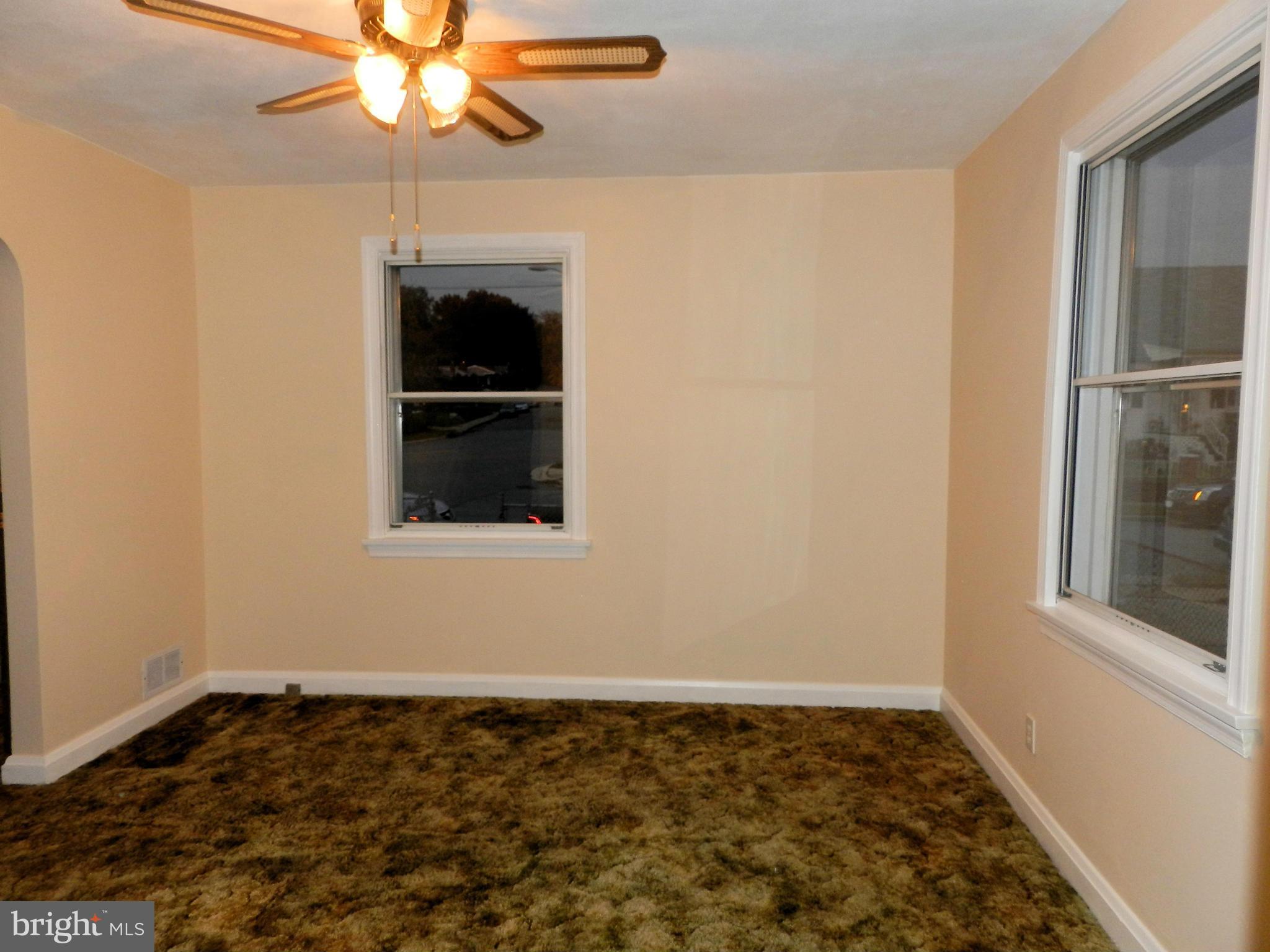 1502 Rita Road Dundalk, MD 21222 - Photo 10 of 21 an empty room with a chandelier fan and windows
