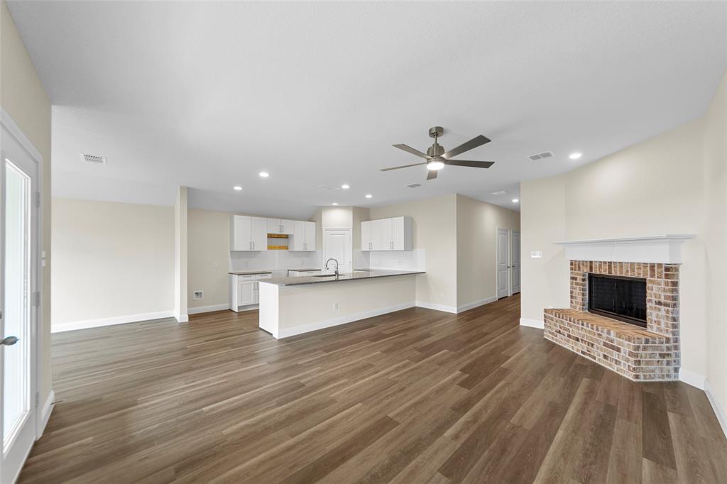 210 Pennington Road Josephine, TX 75173 - Photo 4 of 23 a living room with kitchen island furniture and a fireplace
