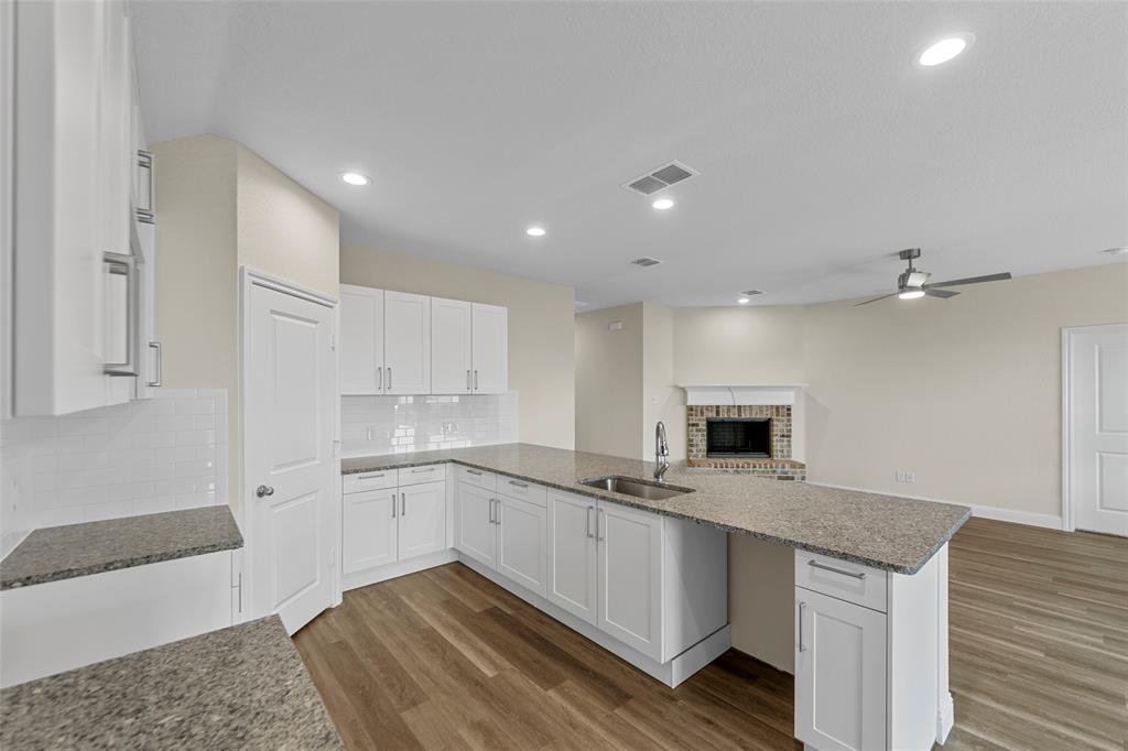 210 Pennington Road Josephine, TX 75173 - Photo 7 of 23 a kitchen with granite countertop a sink stainless steel appliances and white cabinets