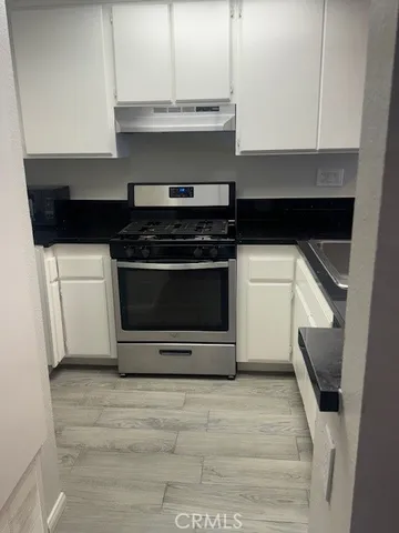 a kitchen with a stove and white cabinets