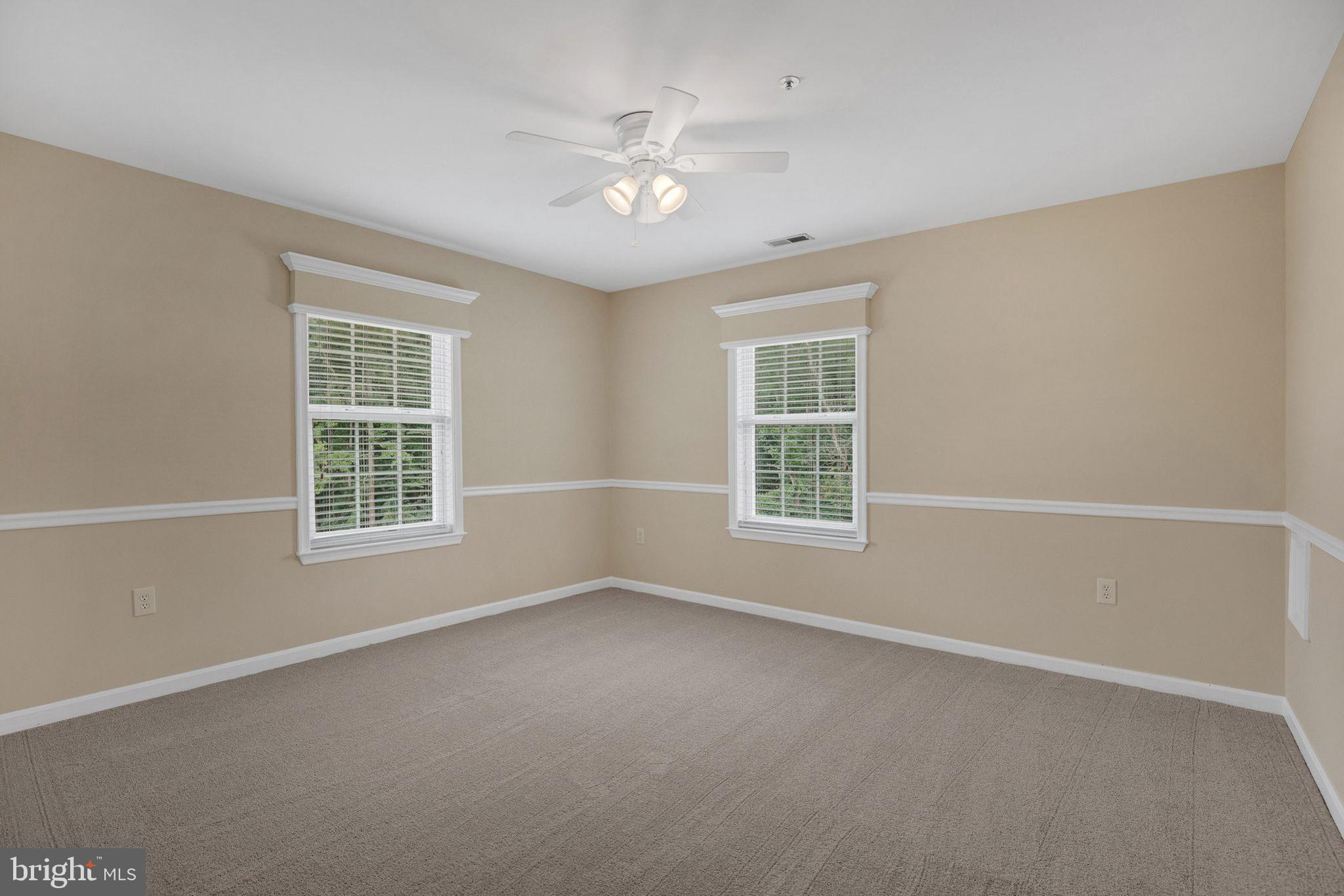 539 Small Reward Road Huntingtown, MD 20639 - Photo 23 of 34 an empty room with windows and chandelier fan