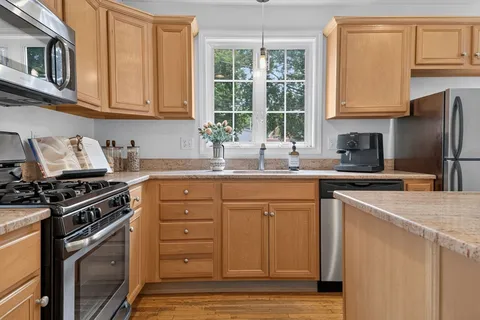 a kitchen with stainless steel appliances granite countertop a sink stove and refrigerator