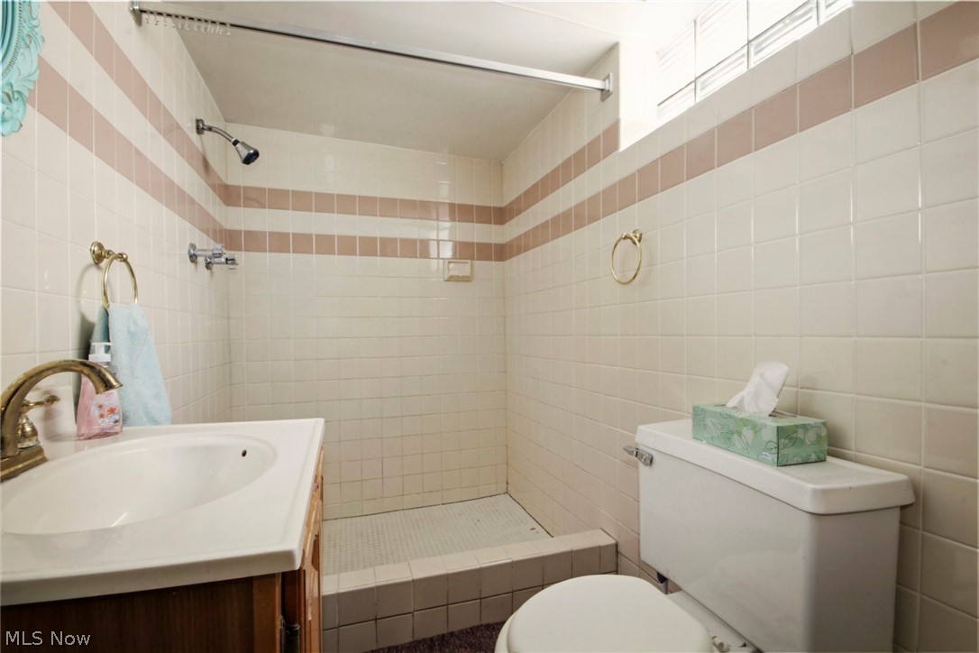 32 Como Street Struthers, OH 44471 - Photo 20 of 22 Bathroom with vanity, a shower stall, and tile walls
