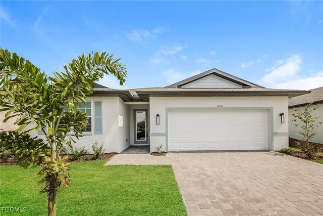 a front view of a house with a garden and yard