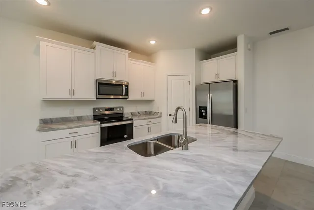 a kitchen with granite countertop a refrigerator and a sink