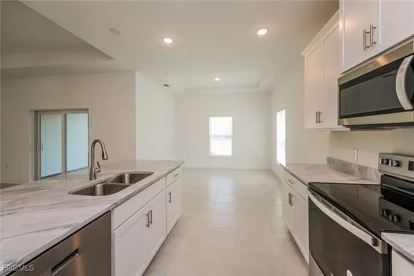 a kitchen with stainless steel appliances granite countertop a sink a stove and a microwave