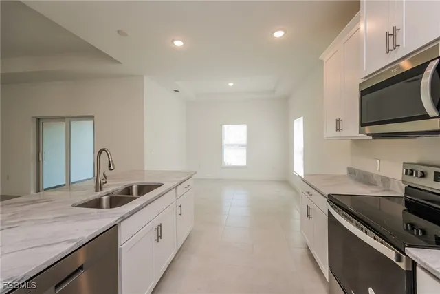 a kitchen with stainless steel appliances granite countertop a sink a stove and a microwave