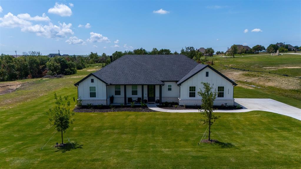 2004 Willy Dilly Road Springtown, TX 76082 - Photo 36 of 40 Modern farmhouse exterior with white vertical siding and dark trim