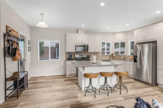 a kitchen with stainless steel appliances granite countertop a refrigerator and a stove top oven