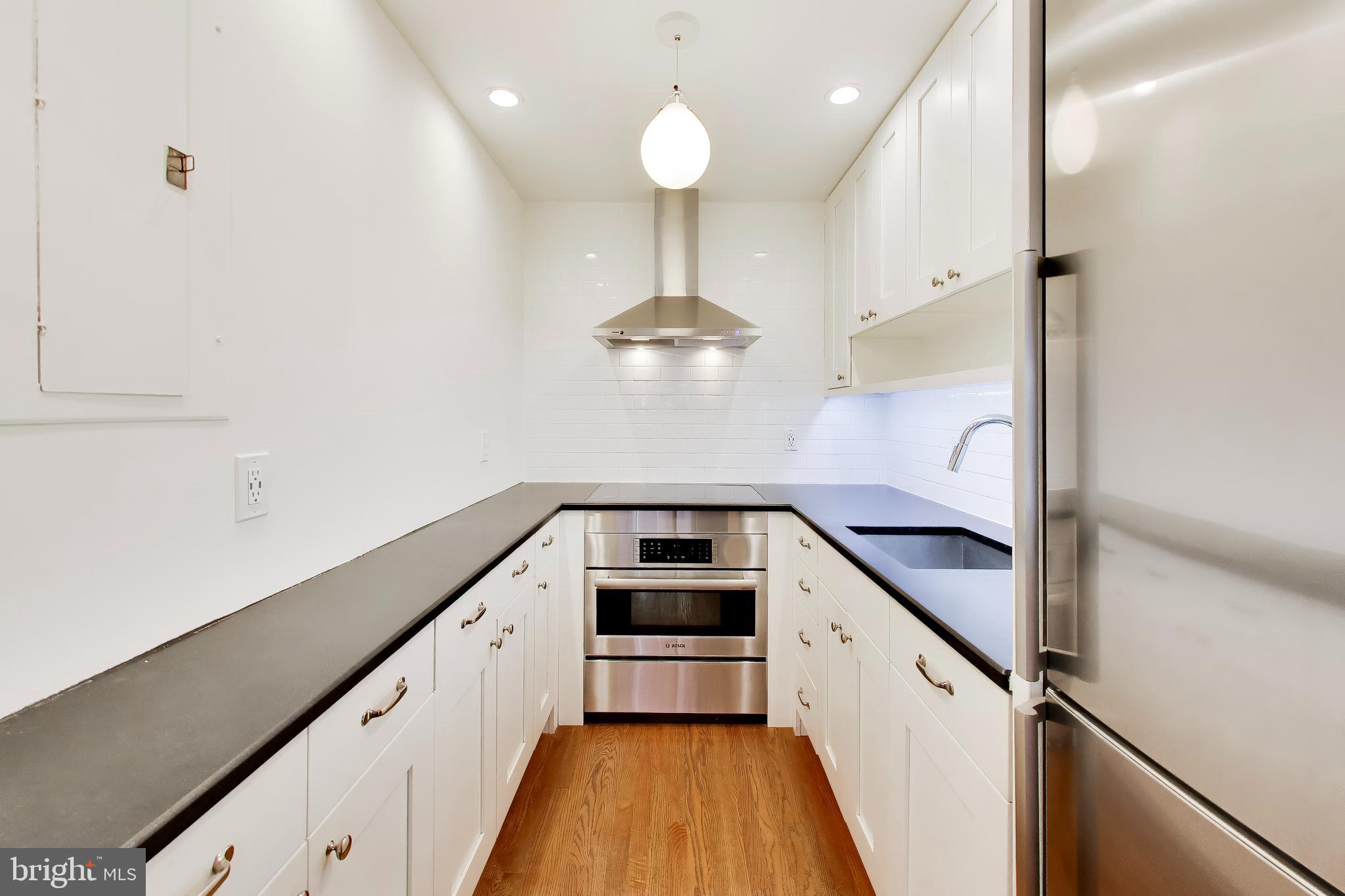 1730 16th Street Northwest, Unit 14 Washington, DC 20009 - Photo 6 of 17 a kitchen with stainless steel appliances a stove a sink and a chandelier