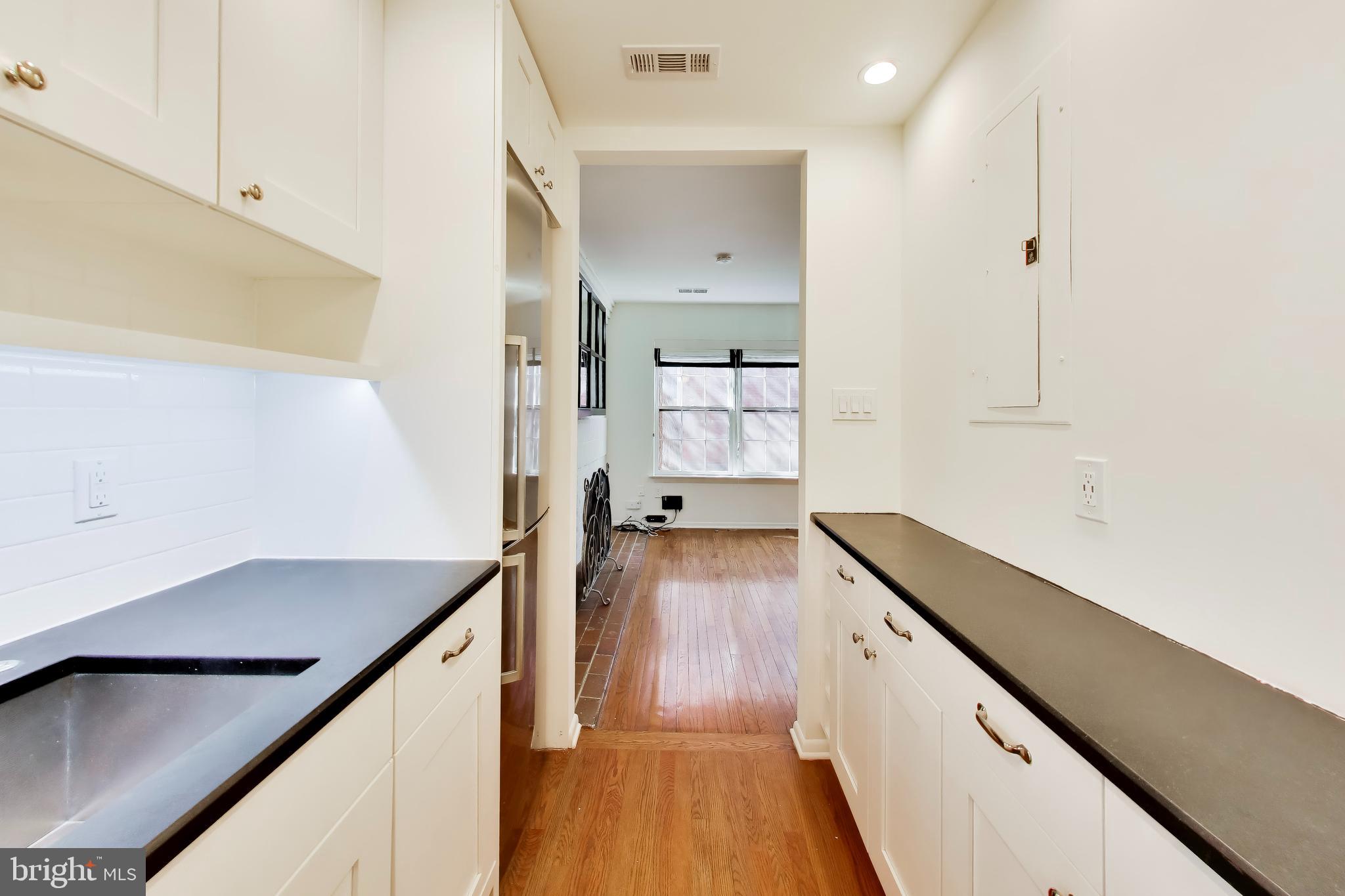 1730 16th Street Northwest, Unit 14 Washington, DC 20009 - Photo 7 of 17 a view of a kitchen with cabinets and wooden floor