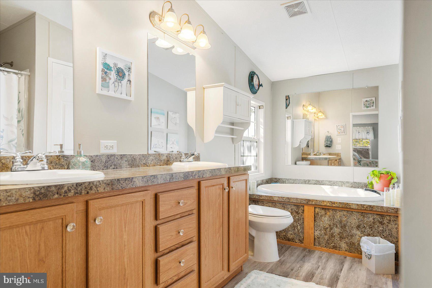 28 Shore Road Sparrows Point, MD 21219 - Photo 5 of 20 a spacious bathroom with a granite countertop sink a toilet a mirror and a bathtub