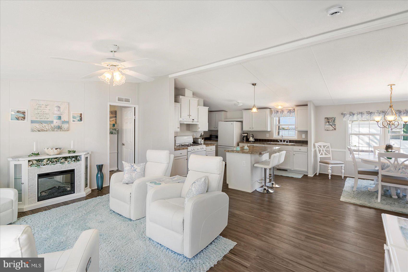 28 Shore Road Sparrows Point, MD 21219 - Photo 9 of 20 a living room with furniture a fireplace and kitchen view