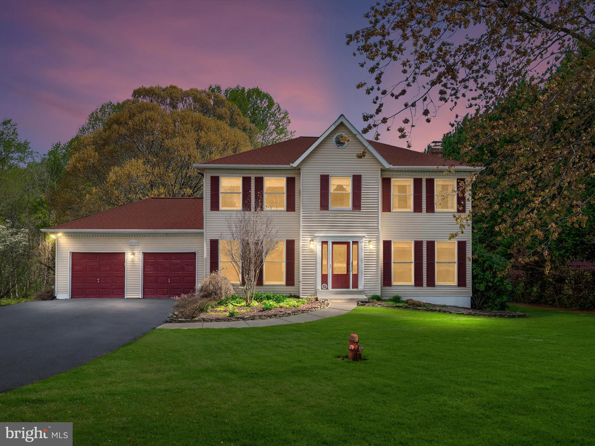 a front view of a house with a yard and trees