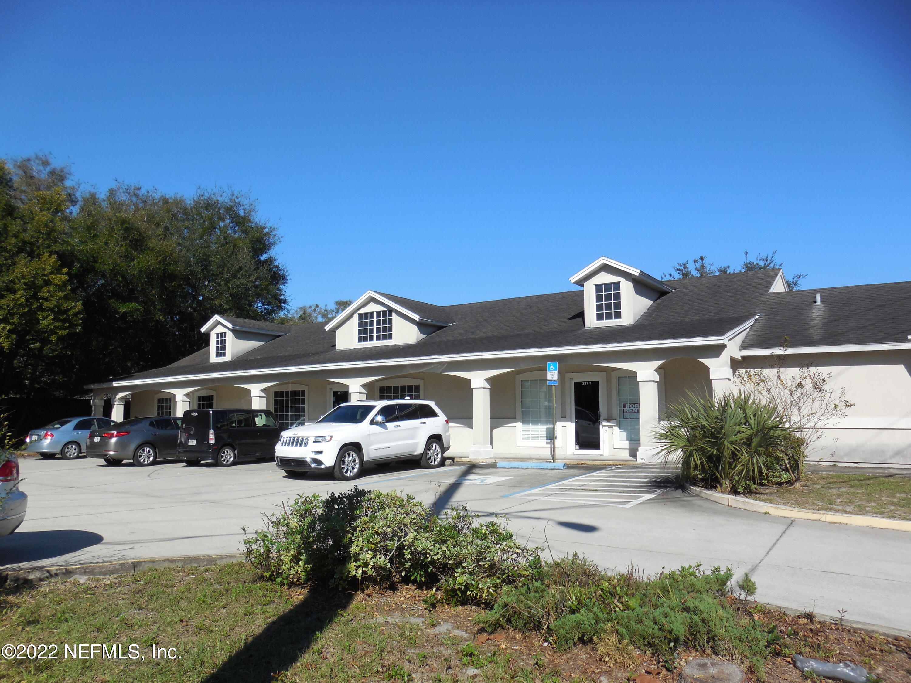 387 New Berlin Road, Unit 1 Jacksonville, FL 32218 - Photo 1 of 4 a front view of a house with a garden and parking