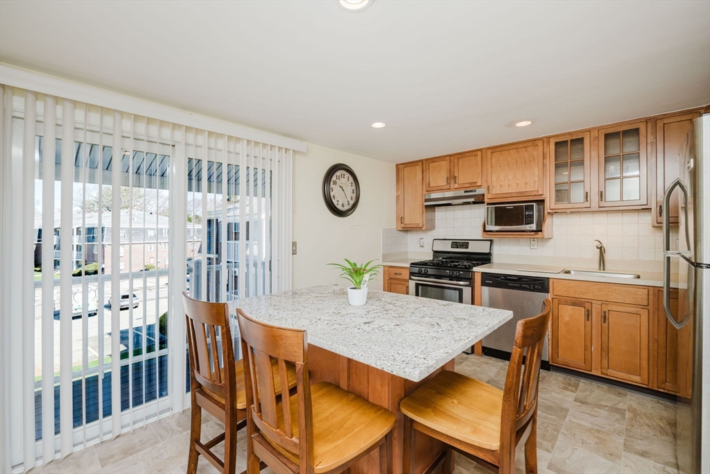 43 Will Drive, Unit 30 Canton, MA 02021 - Photo 8 of 25 a view of a kitchen with granite countertop stainless steel appliances and dining table