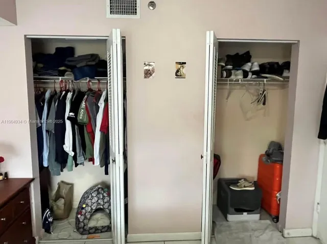 a view of walk in closet with clothes and shoes