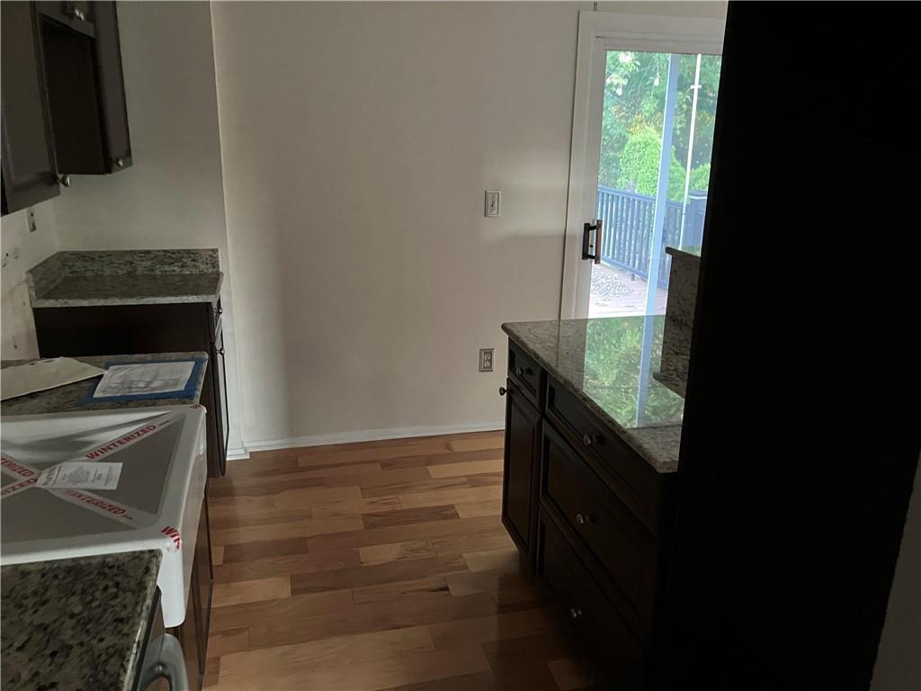 54 Bock Lane Baden, PA 15005 - Photo 14 of 25 a kitchen with granite countertop a stove and a wooden floor