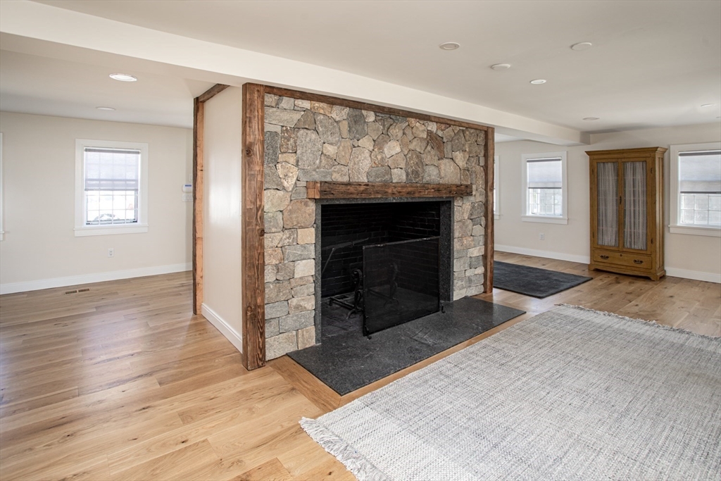 2043 Main Road Westport, MA 02791 - Photo 19 of 42 an empty room with wooden floor fireplace and windows