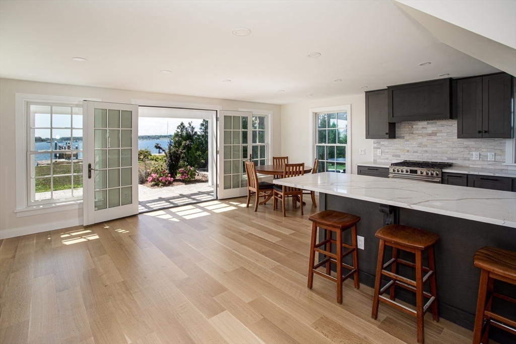 2043 Main Road Westport, MA 02791 - Photo 8 of 42 a open dining room with kitchen island granite countertop wooden floor and a fireplace