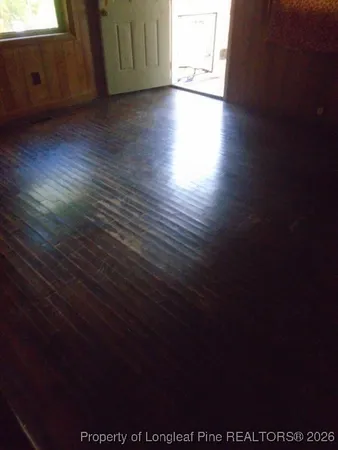 a view of a livingroom with wooden floor and a window